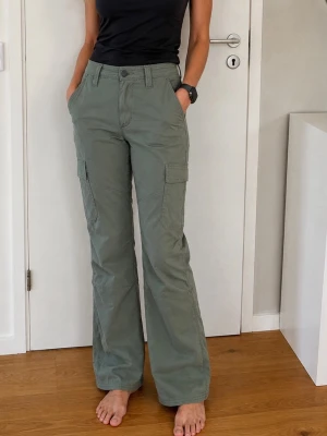 Cargo bootcut byxor Wrangler Stl 26 - Cargo bootcut khakigeöna Wrangler stl 26. Nyskick.