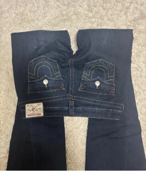 True religion jeans - Mörkblå true religion jeans lågmidjade köpta på jeans bolaget, använda max tre gånger. Inga defekter alls ser helt nya ut strlk 28 säljer pga jag skulle behövt en annan storlek modellen joey