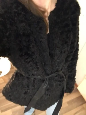 Cubus black faux fur coat (M) - Black faux-fur coat from Cubus, size M, featuring a detachable leather belt. In excellent condition. Shown on a 168 cm tall person in the photos.