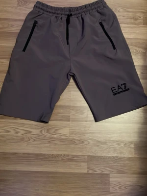 Gröna EA7 shorts med dragkedjor - Gröna EA7 shorts. Den har liten hål i vänstra fickan