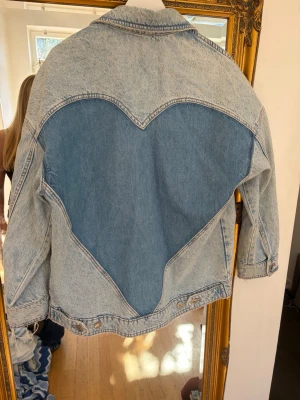 Jeans jacka med hjärta - As cool jeans jacka med ett hjärta på ryggen från Zara! Har några små gräsfläckar längst ner men inget man tänker på🤍