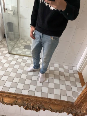  Jack & Jones - Säljer ett par ljusblå jeans från Jack & Jones med klassisk femficksmodell och raka ben. Jeansen har normal midja och är tillverkade i mjuk denim med snygga sömmar. Perfekta för en avslappnad och stilren look.