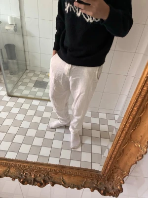 Selected Homme linnebyxor - Regular fit, dropped rise, slim tapered from knee. Säljer ett par vita linnebyxor med avslappnad passform och resår i midjan. Byxorna har sidfickor och två bakfickor med knapp. Perfekta för en chill och stilren look under varmare dagar.