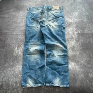 S.Oliver Y2K-jeans för herrar i blått, storlek W36 L33 - Mått: Midja: 48 cm Benslut: 22 cm Lår: 35 cm Totallängd: 104 cm  W/L är uppskattade utifrån måtten.  Skickas inom 24 timmar Spara på priset och frakten genom att sätta ihop ett paket  Mer information finns på min profil 13-278
