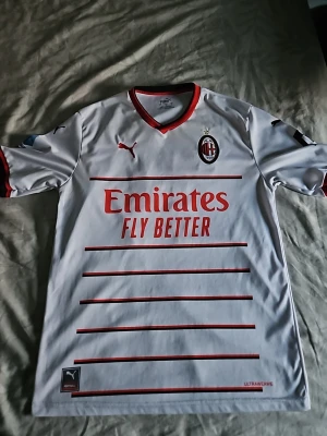 AC Milan bortatröja Ibrahimović - Snygg vit AC Milan bortatröja från Puma med röda detaljer och klubbmärke på bröstet. Baksidan har Ibrahimović och nummer 11. Storlek L men är som M, pga av tvättning.