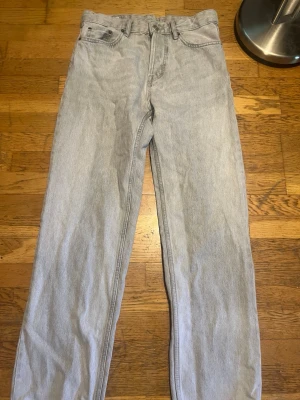 Ljusgrå raka jeans - Säljer ett par ljusgrå jeans med rak passform och hög midja. Jeansen är från Zara. Klassisk femficksmodell med bälteshällor och knappgylf. Jeansen är i ett mjukt denimtyg och har en tidlös look som passar till det mesta. Storleken är ungefär 30-31 