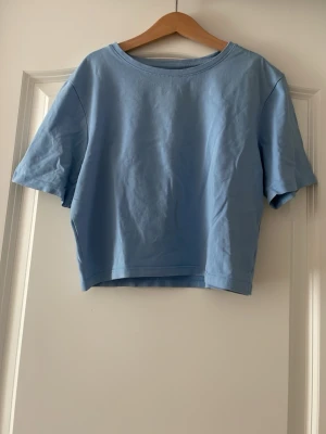 Ljusblå croppad t-shirt från 157 - Säljer en ljusblå croppad t-shirt från 157 i mjuk bomullsblandning med 5% elastan.