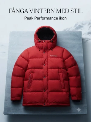 Röd dunjacka från Peak Performance - Snygg röd dunjacka från Peak Performance med huva och svarta detaljer på insidan. Jackan har två stora fickor framtill, dragkedja och tryckknappar. Perfekt för kalla vinterdagar och riktigt varm tack vare dunfyllningen.