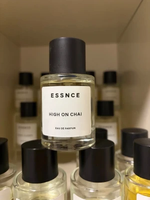 ESSNCE High On Chai parfym - Minimalistisk parfymflaska från ESSNCE med doften High On Chai. Flaskan är genomskinlig med svart skruvlock och vit etikett med svart text. Modern och stilren design som passar perfekt i badrumshyllan.