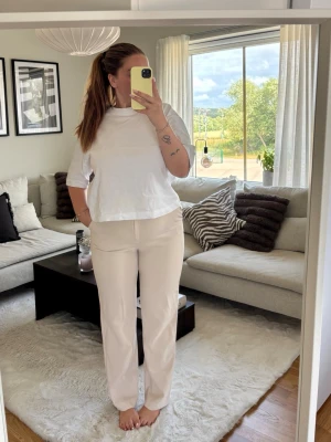 Beiga raka byxor med normal passform - Snygga beiga byxor med rak passform och midja i klassisk höjd. Byxorna är tillverkade i ett mjukt material och har en stilren look som passar till många olika outfits. Perfekta för dig som gillar en enkel och clean stil.