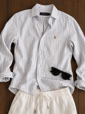 Randig linneskjorta från Ralph Lauren - Snygg vit och ljusgrå randig skjorta i linne från Ralph Lauren. Klassisk krage, långa ärmar och knappar framtill. Ikoniska broderade loggan på bröstet. Perfekt för en avslappnad men stilren look.
