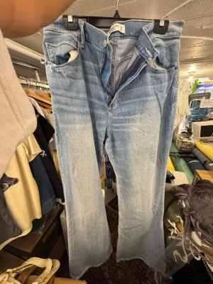 Ljusblå bootcut jeans aber crombie & fitch - Säljer ett par ljusblå bootcut jeans med klassisk femficksdesign och dragkedja. Jeansen har en snygg tvättad look och raka ben som går ut lite nedtill. Perfekta för en avslappnad och trendig stil. Finns att hämta i Gröndal.