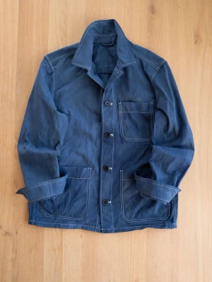 Blue Chore Jacket, size M - Snygg blå overshirt med tre stora fickor framtill och vita kontrastsömmar. Jackan har klassisk krage, knäppning med fyra knappar och raka ärmar. Perfekt lager på lager-plagg för en avslappnad stil.