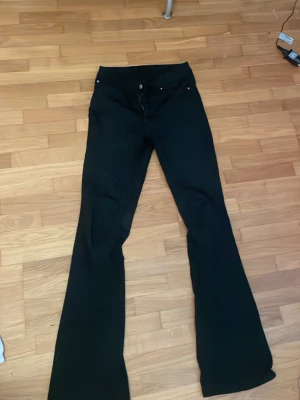 Svarta bootcut jeans från Veromoda - Snygga svarta jeans med bootcut-passform och klassisk femficksdesign. Jeansen har hög midja och vida ben nertill, vilket ger en trendig siluett. Perfekta att styla med sneakers eller boots för en cool look. De är så snygga och är i storlek M 32 men är stora i storleken så om man brukar ha mellan 36-40 i storlek då passar de bra. Jag har storlek 36 och de var pytte lite för stora för mig. Köpte dessa för 600kr 