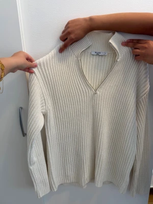 Vit ribbstickad tröja med dragkedja - Vit stickad tröja med silvrig dragkedja. Passar perfekt inför höst och vinter, lite oversized i modellen. Jätte fint stickat material