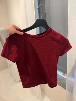 Vinröd kortärmad t-shirt - En enkel och stilren vinröd t-shirt med korta ärmar och rund hals. Perfekt basplagg som passar till det mesta. Tillverkad i mjukt bomullstyg för skön känsla hela dagen.