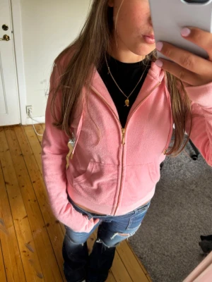 Ljusrosa juicy  hoodie  - Säljer en ljusrosa hoodie med dragkedja och huva. Hoodien har fickor framtill och vita snören vid huvan. Materialet ser ut att vara mjukt och lite fluffigt, perfekt för en chill look. Passar dig som gillar en avslappnad och söt stil. Pris kan diskuteras 