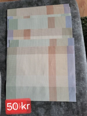 Pastellfärgade bordstabletter - 7 bordstabletter i pastellfärger med rutigt mönster i beige, grönt, blått och orange. Tillverkade i ett plastliknande material som är lätt att torka av. Perfekta för att skydda bordet och ge en färgklick till dukningen.