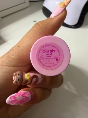 Blush Coral Crush i rosa hylsa från daar - Säljer ett blush i färgen Coral Crush med en söt rosa hylsa dekorerad med glittriga stenar. Rouget är i stickform och väger 8 g. Perfekt för att ge kinderna en fräsch, korallfärgad ton.