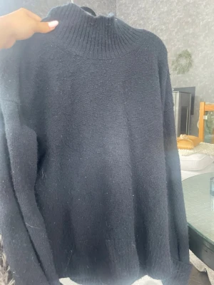 Svart stickad tröja från BikBok - Mysig svart stickad tröja från BikBok i mjuk lammull. Köpt på karlaplanloppis. Nopprig men de går o h lösa med noppermaskin om man har de 🥹🥰