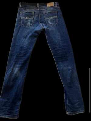 Nudie jeans Lean Dean W33 L34 - Superfina Nudie jeans i en riktigt fräsch blå tvätt med otroligt snygga, naturliga fades över lår och baksida! Jeansen är helt intakta och i mycket bra skick inga hål, repor eller slitningar i grenen. Sitter perfekt och har de klassiska orangea Nudie-sömmarna baktill. 