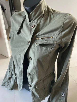 Avant garde vintage jacka - Snygg olivgrön utilityjacka med hög krage och flera fickor med dragkedja och knappar. I toppen skick, köpt från vinted men är för liten för mig 🥲passar som en xs