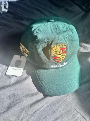 Aime Leon Dore keps - Säljer en snygg Aime Leon Doré x Porsche keps. Aldrig använd, lappar kvar. No size