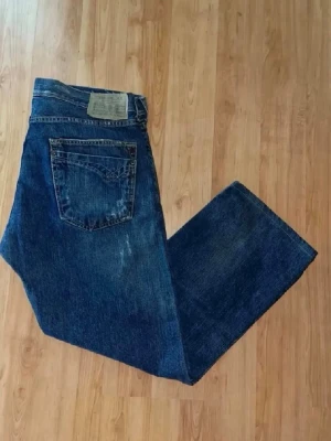 Replay jeans  - Säljer ett par jeans från Replay, modell Gybson. Jeansen har en klassisk blå färg men små slitningar och rak i modell. Midja 45cm, längd 93cm. OBS uppsydda för att passa L30 men utgå från måtten och ej storlekslappenJAG SKICKAR EJ FLER BILDER NÄR JAG BÄR JEANSEN! för bättre inblick i passformen rekommenderar jag att googla på modellnamnet. För storleksguide kolla måtten noggrant då jeansen alltid kan vara uppsydda heller krympta och jag ej tar emot returer :)  )r11)