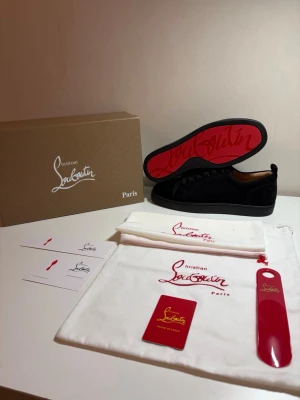 Svarta sneakers från Christian Louboutin - Säljer ett par as feta svarta sneakers från Christian Louboutin i storlek 43. Skorna är i helt nytt skick, aldrig använda utan bara testade. Skorna kommer med original box, äkthetets kort och allt annat som syns i bilden. Priset är ej hugget i sten så kom gärna med bud!