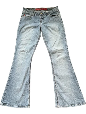 Vintage Ljusblå lowrise bootcut jeans från Mudd - Säljer ett par äkta vintage ljusblå bootcut jeans från Mudd. Jeansen har låg midja och är tillverkade i slitstark denim med lätt tvättad look. Mått: midja: 40 cm, innerbenslängd: 82 cm 💕Skulle säga att de är mellan lowrise och midrise. Jeansen har stretch och sitter väldigt smickrande!