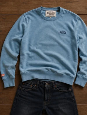 Ljusblå sweatshirt från Superdry - Ljusblå sweatshirt från Superdry med rund halsringning och diskret logga broderad på bröstet. Tröjan har ribbade muddar vid ärmslut och nederkant samt en liten orange Superdry-detalj på ärmen. Perfekt för en avslappnad stil.