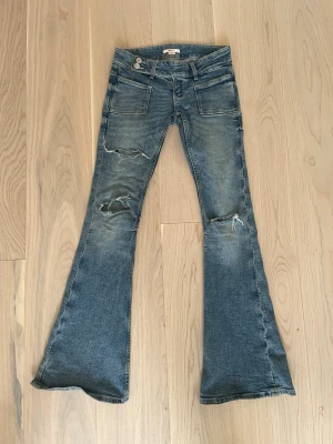 blå low waist bootcut jeans - säljer ett par Gina Tricot low waist bootcut jeans i strl xxs, dom är i ganska bra skick skulle jag säga, bara lite slitna vid hålen😌😚