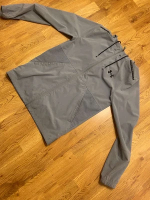 Grå under armour vind jacka - Grå under armour vind jacka med svart logga och skönt material för hösten och tidigare på våren