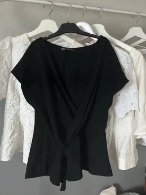 Svart omlottopp från Zara - Svart omlotttopp från Zara med fin passform och mjukt, följsamt tyg. Passar både till vardag och fest