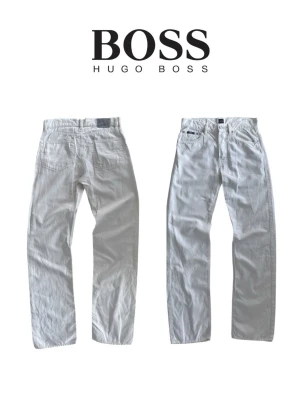 Vita raka jeans från Hugo Boss - Snygga vita jeans från Hugo Boss med rak passform och klassisk femficksdesign. Jeansen har diskreta detaljer och är tillverkade i ett mjukt bomullstyg som ger en clean och fräsch look.