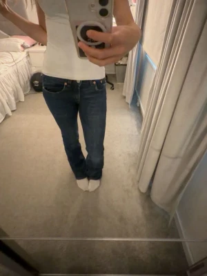 Mörkblå bootcut jeans - Säljer ett par mörkblå bootcut jeans med klassisk femficksdesign och normal midja. Perfekt att styla till allt!!