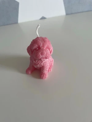 Rött doftljus i form av hund - Säljer ett gulligt ljus format som en liten hund i röd färg. Ljuset har detaljerad pälsstruktur och en veke på toppen. Perfekt som dekoration eller present till någon som gillar hundar och unika ljus. Doftar gott av jordgubb