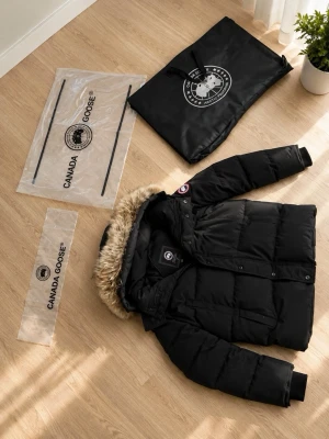  Canada Goose jacka storlek S - Säljer en äkta  svart dunjacka från Canada Goose med avtagbar huva och pälskant. Jackan har klassisk patch på ärmen, dragkedja och knappar framtill samt flera fickor. Perfekt för kalla vinterdagar och riktigt varm tack vare dunfyllningen. Jackan är äkta. Rabbat bara 7. Dagar 