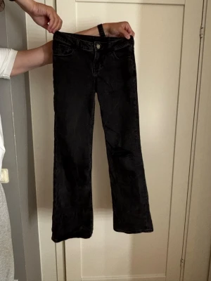 Svarta bootcut jeans med slitning - Säljer ett par svarta bootcut jeans med en snygg slitning på ena benet. 
