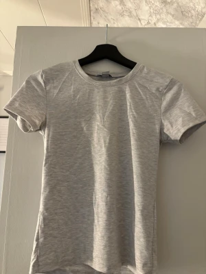 Basic grå tajt t-shirt - Grå t-shirt ifrån new yorker, säljer för att jag aldrig använt den. Vill mest bara bli av med den. Pris går att diskutera 🤗