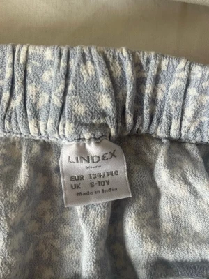 Blommig kjol - Jag säljer en blå blommig omlottkjol från Lindex i storlek 134/140❣️