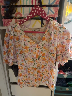 Blommig blus med puffärm, v-ringad - Somrig blus kroppad. Korta ärmar. 🌼