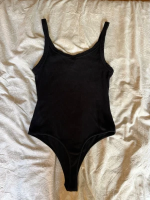 Body  - Säljer en basic svart body som är smått ribbad. Den är endast använd en gång och har inga skavanker. Lappen är dessvärre inte kvar längre men skulle gissa på att den är från Zara eller liknande märke 