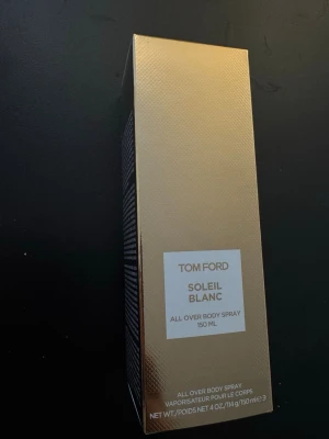 Tom Ford Soleil Blanc Body Spray 150 ml - Tom Ford Soleil Blanc All Over Body Spray i elegant vit och guld förpackning. Flaskan rymmer 150 ml och har en lyxig känsla med metallisk etikett. Perfekt för dig som vill ha en exklusiv doftupplevelse i vardagen.