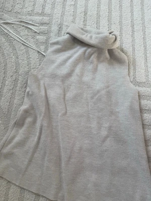 Beige ärmlös stickad polotröja - Säljer en beige ärmlös stickad polotröja i mjukt material. Från Zara i storlek M
