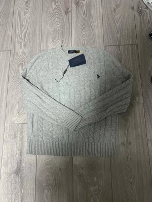 Grå kabelstickad tröja Polo Ralph Lauren - Använd ett par gånger men i mycket bra skick , pris kan diskuteras 