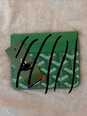 Guyard plånbok  - Snygg grön korthållare med mönstrad framsida och flera kortfack. Tillverkad i läder med stilren design och vita detaljer i mönstret. Perfekt för att hålla ordning på dina kort i fickan.