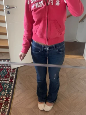 Mörkblå bootcut jeans med låg midja - Säljer ett par mörkblå bootcut jeans med låg midja och vita sömmar, från Bikbok 