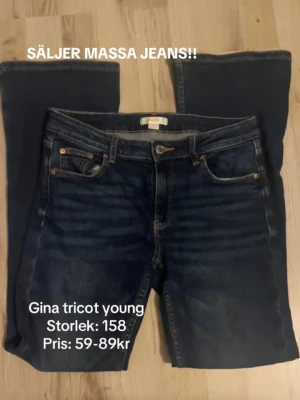 Mörkblå bootcut jeans Gina Tricot - Snygga mörkblå jeans från Gina Tricot Young med klassisk femficksmodell och bootcut ben. Jeansen har kontrastsömmar och knappgylf. Perfekta för dig som gillar en enkel och tidlös stil.