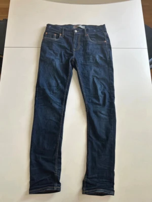Levi’s Jeans - Snygga mörkblå skinny jeans från Levi's med klassiska fem fickor och kontrastsömmar. Jeansen har en smal passform och är tillverkade i ett stretchigt denimtyg för extra komfort. Perfekta till en avslappnad streetstyle-look. Modellen är 512 Slim Taper. Hör av dig om du har några frågor!